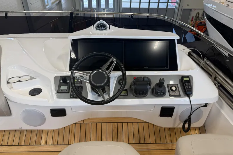 F45095 Yacht Photos Pics Control panel of 2023 Princess F45 yacht with steering wheel and navigation screens.