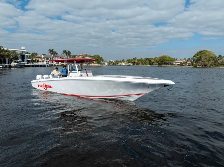 Havana Club Yacht Photos Pics 2023 Fountain 38 SC boat cruising on a scenic waterway under a partly cloudy sky.