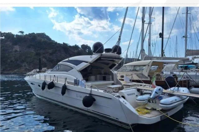  Yacht Photos Pics Luxury Cayman Yachts 55-58 Walkaround HT, 2003 model, docked in a scenic marina.