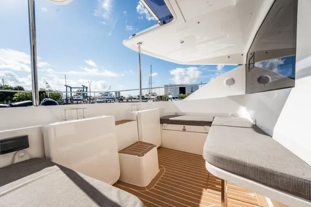 Catfish Yacht Photos Pics 2017 Leopard 51 Powercat yacht interior with cushioned seating and wooden flooring under a clear sky.
