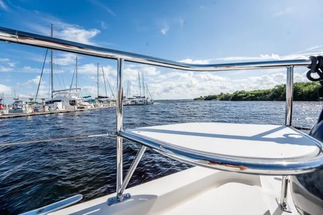 Catfish Yacht Photos Pics 2017 Leopard 51 Powercat on water, marina view, sunny day, blue sky, sailboats in background.