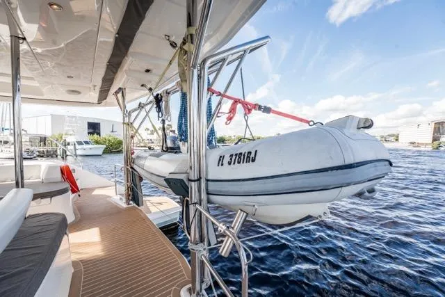 Catfish Yacht Photos Pics 2017 Leopard 51 Powercat with dinghy on deck, docked by the water.