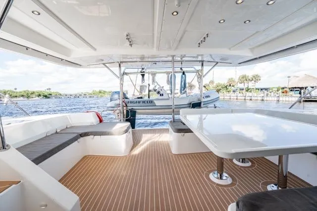 Catfish Yacht Photos Pics 2017 Leopard 51 Powercat yacht interior with spacious seating and table, overlooking serene waters.