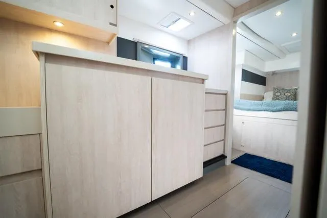 Catfish Yacht Photos Pics Interior of 2017 Leopard 51 Powercat, featuring modern cabinetry and cozy sleeping area.