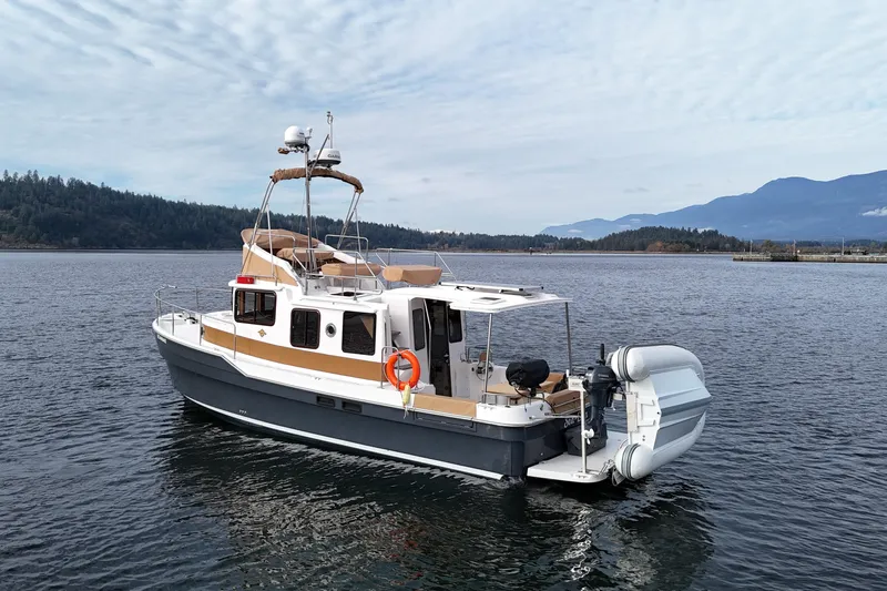  Yacht Photos Pics 2021 Ranger Tugs R-31 CB boat on calm water with scenic mountain backdrop.