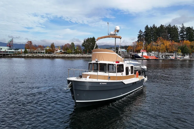  Yacht Photos Pics 2021 Ranger Tugs R-31 CB boat cruising on a scenic lake with autumn trees.