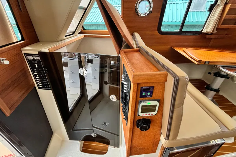  Yacht Photos Pics 2021 Ranger Tugs R-31 CB interior with control panel and wooden accents.