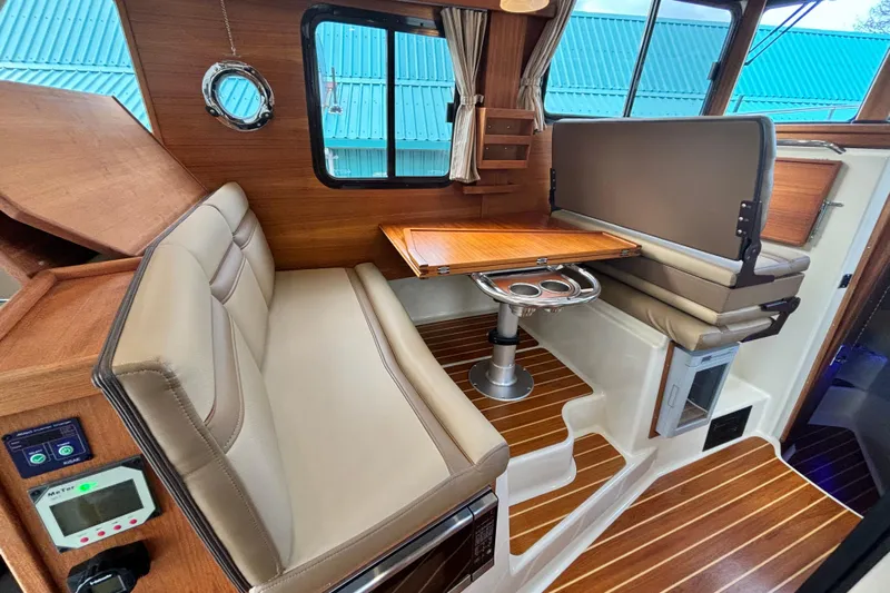  Yacht Photos Pics 2021 Ranger Tugs R-31 CB interior with wood accents and beige seating.