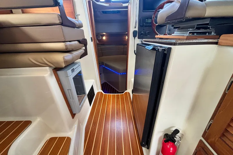  Yacht Photos Pics 2021 Ranger Tugs R-31 CB interior with wood flooring, seating, and compact kitchen area.