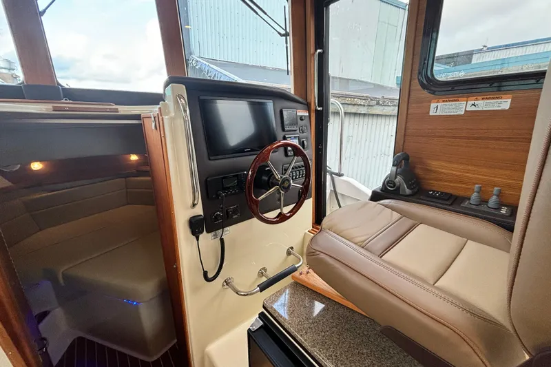  Yacht Photos Pics 2021 Ranger Tugs R-31 CB interior with helm, seating, and navigation equipment.