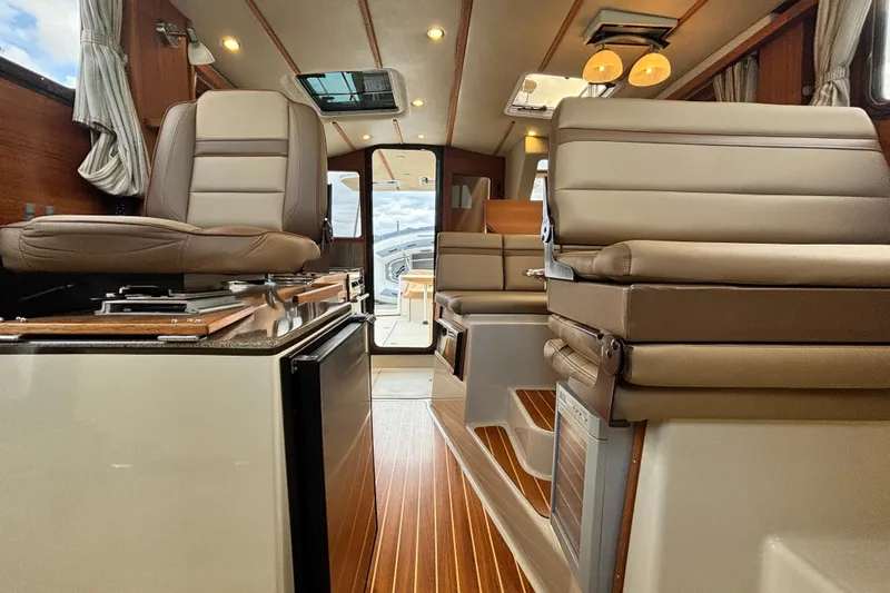  Yacht Photos Pics Interior of 2021 Ranger Tugs R-31 CB, featuring luxurious seating and wood flooring.