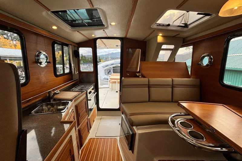  Yacht Photos Pics Interior of 2021 Ranger Tugs R-31 CB, featuring a cozy seating area and kitchenette.