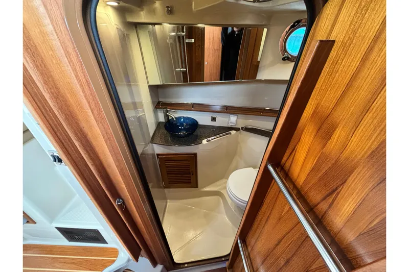  Yacht Photos Pics 2021 Ranger Tugs R-31 CB bathroom interior with wooden door and modern fixtures.
