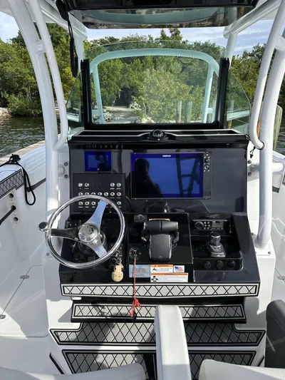 Even Or Odd Yacht Photos Pics 2023 Wellcraft 302 Fisherman boat dashboard with steering wheel and navigation controls.