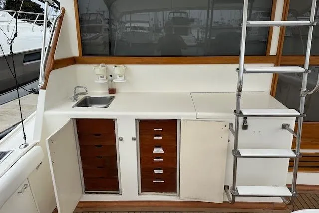Reel'n In Style Yacht Photos Pics 1988 Ocean 44' Super Sport yacht interior with sink, storage, and ladder.