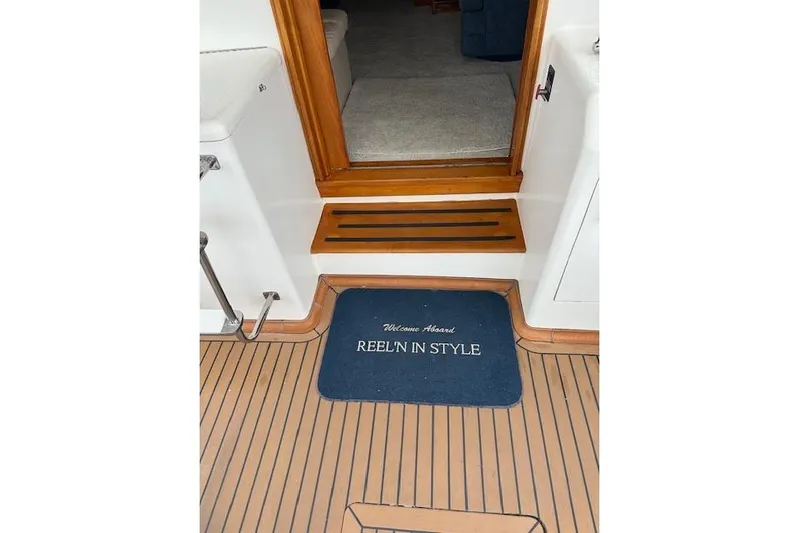 Reel'n In Style Yacht Photos Pics Welcome mat on 1988 Ocean 44' Super Sport yacht, wooden deck, cabin entrance.