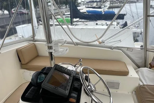 Reel'n In Style Yacht Photos Pics 1988 Ocean 44' Super Sport yacht helm with navigation equipment and marina view.