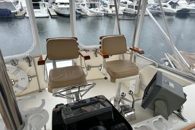 Reel'n In Style Yacht Photos Pics 1988 Ocean 44' Super Sport yacht helm with dual seats and marina view.