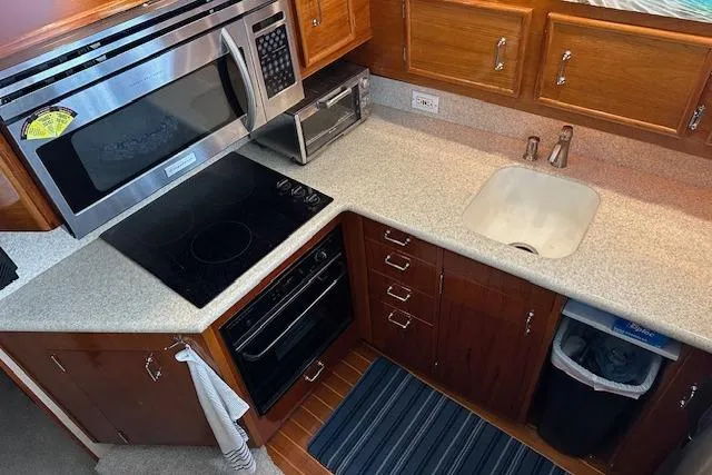 Reel'n In Style Yacht Photos Pics 1988 Ocean 44' Super Sport yacht kitchen with modern appliances and wooden cabinetry.
