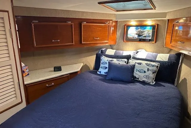 Reel'n In Style Yacht Photos Pics Cozy bedroom in 1988 Ocean 44' Super Sport yacht with blue bedding and wooden cabinets.