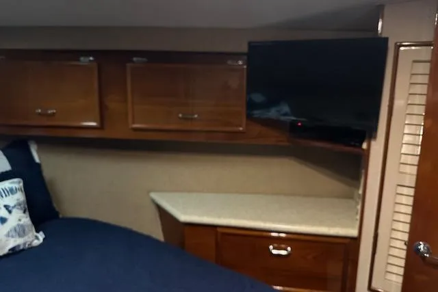 Reel'n In Style Yacht Photos Pics Interior of 1988 Ocean 44' Super Sport yacht with wood cabinets and mounted TV.