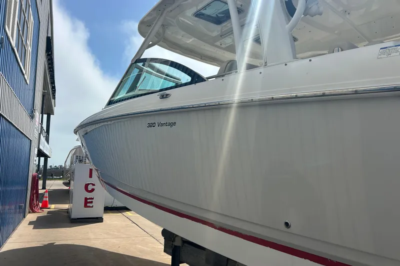  Yacht Photos Pics 2017 Boston Whaler 320 Vantage boat docked near a building under sunlight.