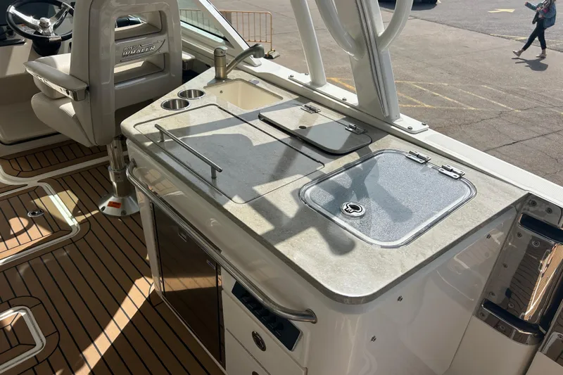  Yacht Photos Pics 2017 Boston Whaler 320 Vantage boat interior with helm and kitchenette area.