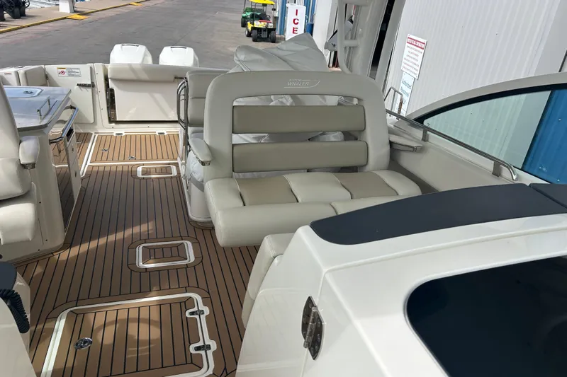  Yacht Photos Pics 2017 Boston Whaler 320 Vantage boat interior with cushioned seating and wood-patterned flooring.