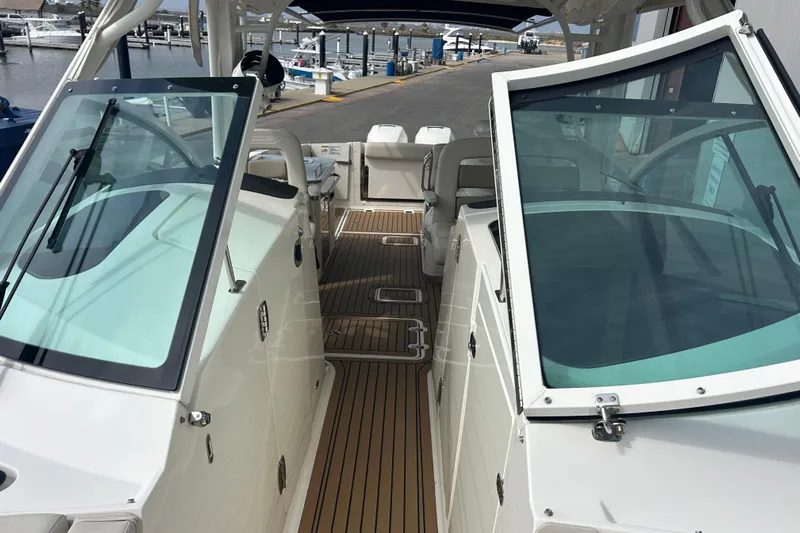  Yacht Photos Pics 2017 Boston Whaler 320 Vantage boat interior with open windshield and wooden deck.