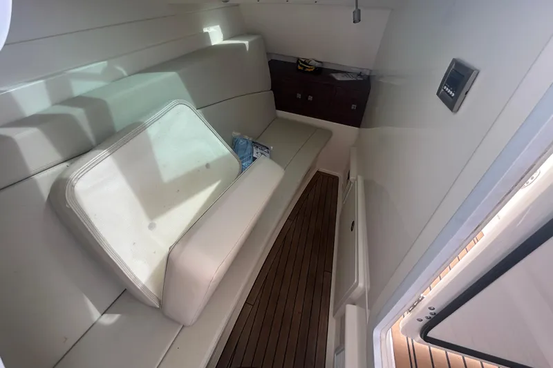  Yacht Photos Pics 2017 Boston Whaler 320 Vantage cabin interior with seating and wooden flooring.