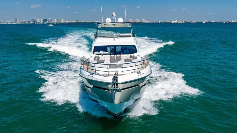 Bongani Yacht Photos Pics 2024 Azimut Fly 78 yacht cruising on open water, city skyline in background.