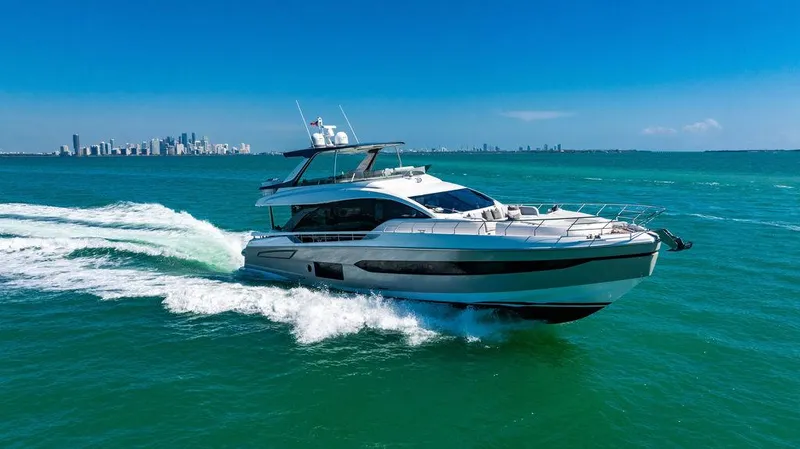 Bongani Yacht Photos Pics 2024 Azimut Fly 78 yacht cruising on turquoise ocean with city skyline in background.