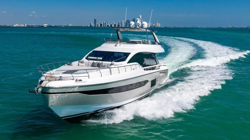Bongani Yacht Photos Pics 2024 Azimut Fly 78 yacht cruising on turquoise waters with city skyline in background.