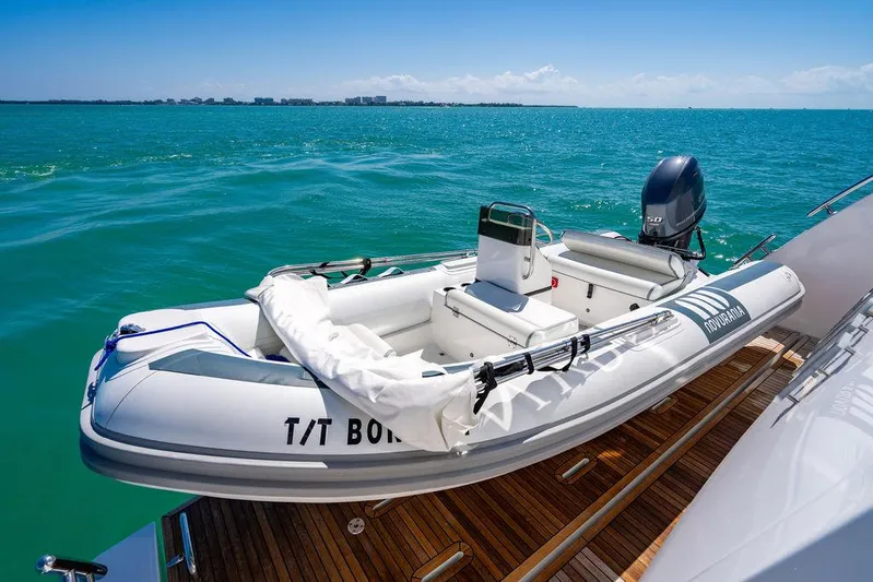 Bongani Yacht Photos Pics 2024 Azimut Fly 78 yacht with a tender boat on deck, cruising in clear blue waters.