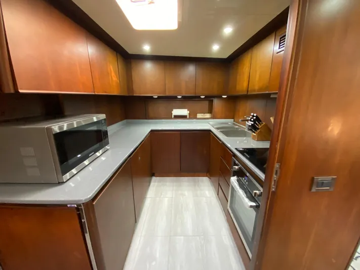  Yacht Photos Pics Luxurious kitchen in 2007 Rodriquez 80 Widebody yacht with modern appliances and wood cabinetry.