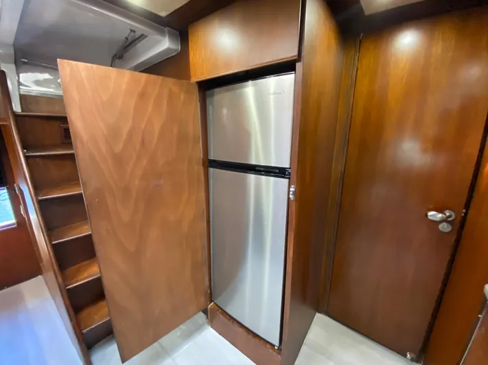  Yacht Photos Pics Wood-paneled interior of 2007 Rodriquez 80 Widebody yacht with stainless steel refrigerator.