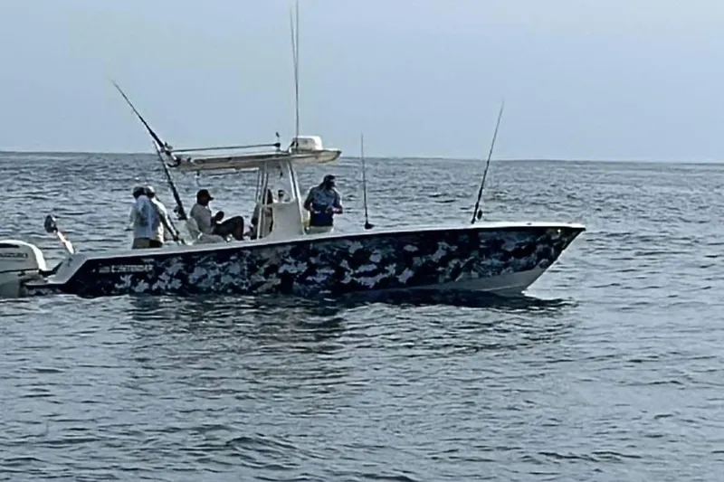  Yacht Photos Pics 2001 Contender 27 Open CC boat with fishing rods on open water.