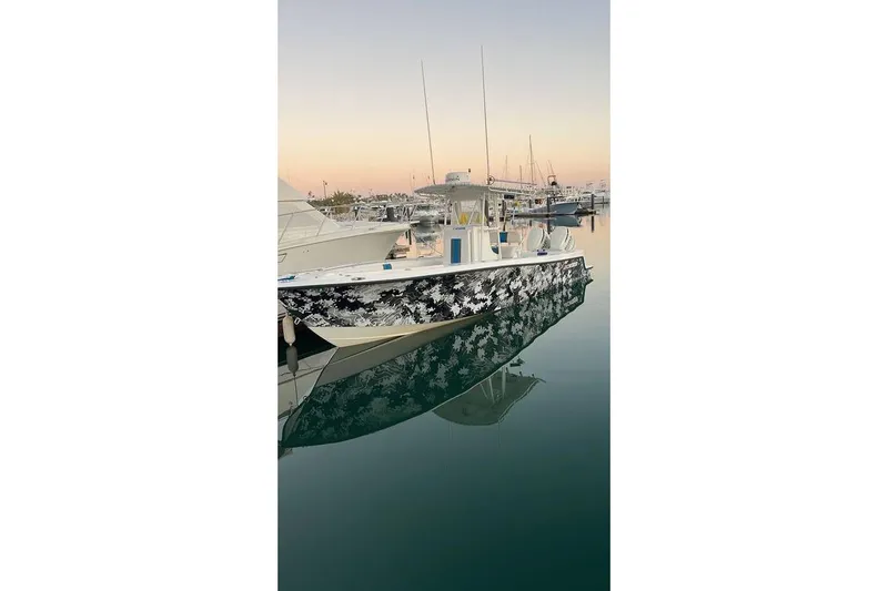  Yacht Photos Pics 2001 Contender 27 Open CC boat with camouflage design docked at sunset.