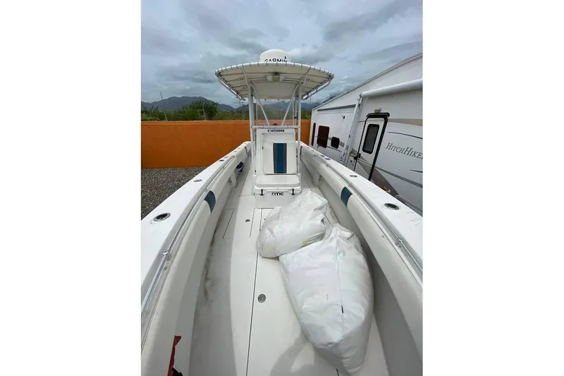  Yacht Photos Pics 2001 Contender 27 Open CC boat with T-top, parked near RV and orange wall.