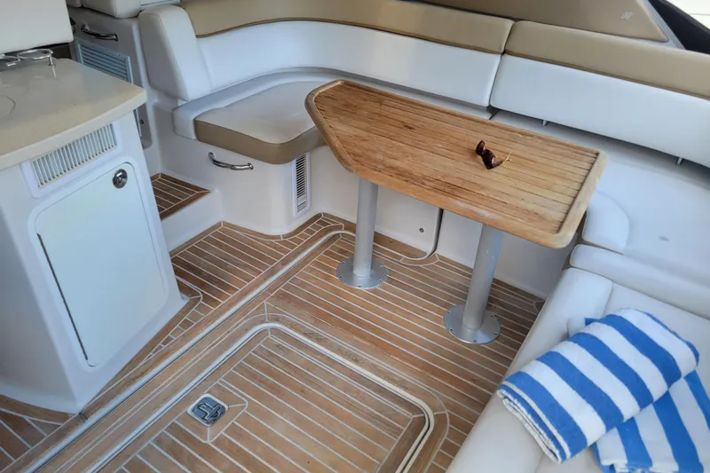 Isabella IV Yacht Photos Pics Luxurious 2012 Four Winns V435 yacht interior with wooden table and striped towel.