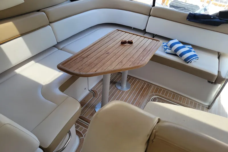 Isabella IV Yacht Photos Pics Luxurious seating area on 2012 Four Winns V435 yacht with wooden table and striped towel.