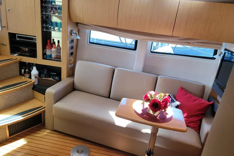 Isabella IV Yacht Photos Pics Luxurious interior of 2012 Four Winns V435 yacht with sofa, table, and bar area.
