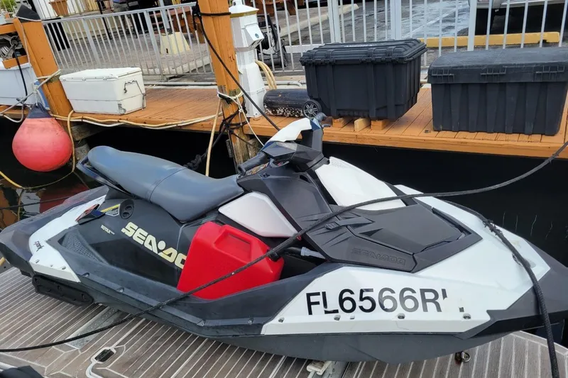 Isabella IV Yacht Photos Pics Jet ski docked beside a Four Winns V435, 2012 model, at a marina.