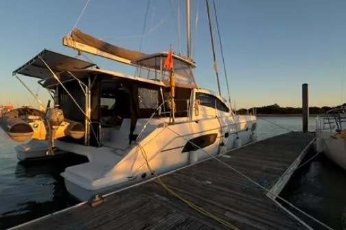 The Light Yacht Photos Pics 2014 Leopard 44 catamaran docked at sunset, showcasing sleek design and spacious deck.