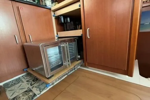 The Light Yacht Photos Pics Microwave in Leopard 44 yacht kitchen, 2014 model, with wooden cabinetry and tiled flooring.