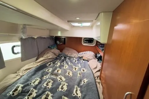 The Light Yacht Photos Pics Cozy cabin interior of 2014 Leopard 44 catamaran with bed and porthole.