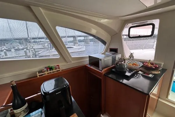 The Light Yacht Photos Pics Interior of 2014 Leopard 44 yacht with kitchen and marina view through windows.