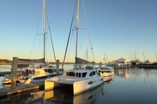 The Light Yacht Photos Pics 2014 Leopard 44 catamaran docked at a serene marina during sunset.