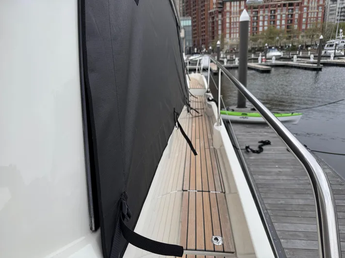 Yacht Photos Pics Side deck of 2023 Prestige 520 F-Line yacht at marina, featuring sleek design and wood finish.