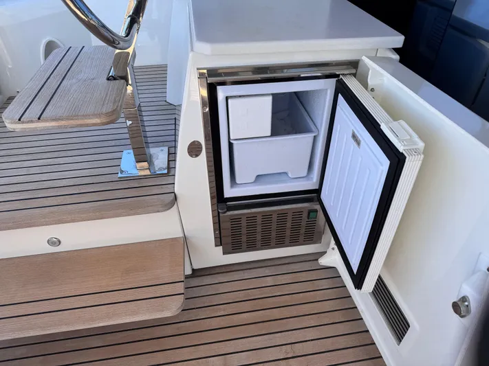  Yacht Photos Pics Open mini fridge on 2023 Prestige 520 F-Line yacht with wooden deck.
